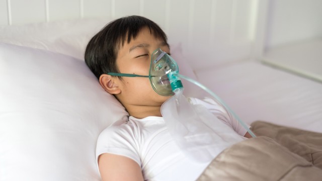 Ilustrasi anak sakit menggunakan masker oksigen berbaring di tempat tidur rumah sakit. Foto: TinnaPong/Shutterstock