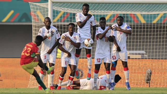 Pemain Guinea Aguibou Camara menendang bola ke arah gawang Gambia pada pertandingan 16 besar Piala Afrika 2021 di Stade de Kouekong, Bafoussam, Kamerun, Senin (24/1/2022).  Foto: Thaier Al-Sudani/REUTERS