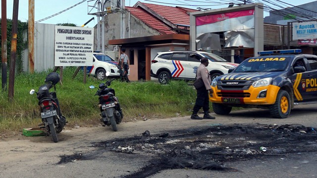 Sejumlah polisi berjaga di tempat hiburan malam Double O mengungsi usai bentrokan di Kota Sorong, Papua Barat, Selasa (25/1/2022). Foto: Olha Mulalinda/Antara Foto