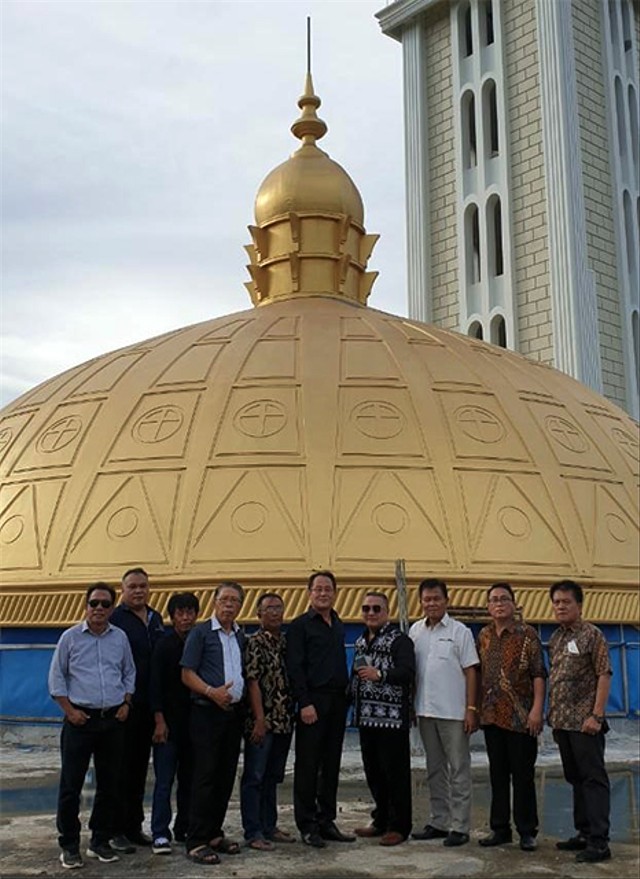 Panitia pembangunan Gedung Gereja Masehi Injili di Minahasa (GMIM) Getsemani Sario Kota Batu (Sakobar) Manado, berfoto bersama dengan latar atap kubah emas milik gereja tersebut. (foto: istimewa)