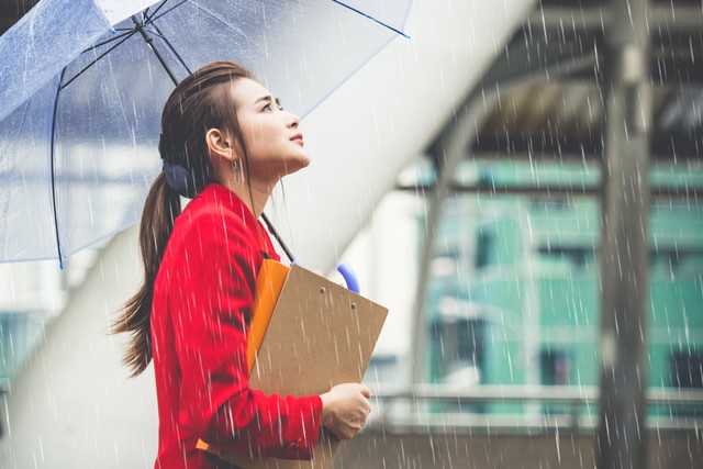 Pekerja menggunakan payung saat melintasi hujan. Foto: Nattakorn_Maneerat/Shutterstock