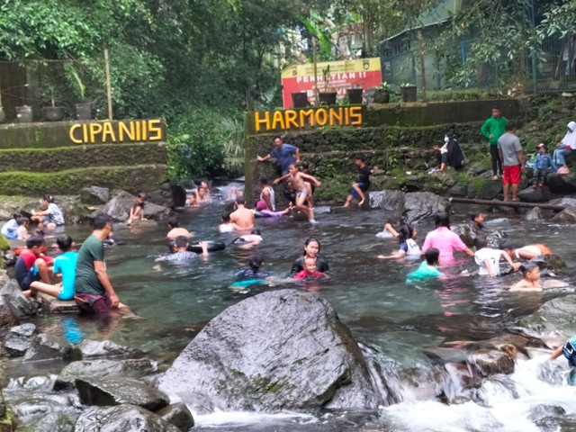 Pengunjung dewasa dan anak-anak menikmati segarnya air sungai di wisata alam Cipaniis Kabupaten Kuningan Jawa Barat.(Juan)