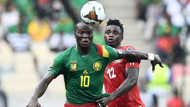 Pemain Kamerun Vincent Aboubakar beraksi dengan pemain Gambia James Gomez pada perempat final Piala Afrika (CAN) 2021 di Stadion Japoma di Douala, Kamerun, Sabtu (29/1/2022). Foto: Charly TRIBALLEAU/AFP