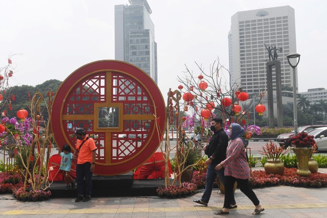 Warga melintasi ornamen bernuansa Imlek yang di pasang di kawasan Bundaran Hotel Indonesia, Jakarta, Minggu (30/1/2022). Foto: Akbar Nugroho Gumay/ANTARA FOTO