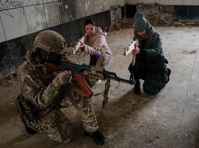 Seorang veteran dari batalyon Pengawal Nasional Ukraina Azov melakukan pelatihan militer untuk warga sipil di tengah ancaman invasi Rusia di Kyiv, Ukraina, Minggu (30/1/2022). Foto: Gleb Garanich/REUTERS