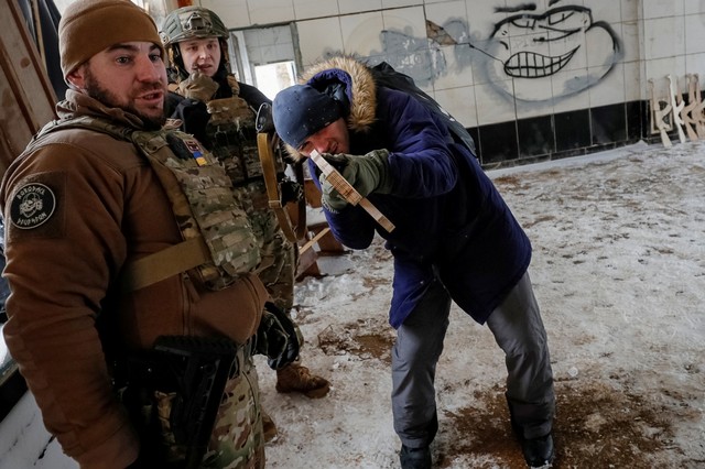 Seorang veteran dari batalyon Pengawal Nasional Ukraina Azov melakukan pelatihan militer untuk warga sipil di tengah ancaman invasi Rusia di Kyiv, Ukraina, Minggu (30/1/2022). Foto: Gleb Garanich/REUTERS