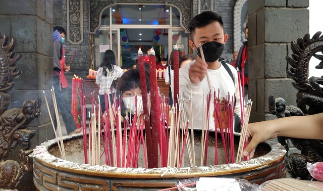 Umat Buddha meletakkan dupa menyala saat berada di Vihara Sakyakirti. (Foto: M Sobar Alfahri/Jambikita)