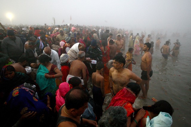 Umat Hindu berenang di perairan Sangam, pertemuan sungai Gangga, Yamuna dan Saraswati untuk menandai Mauni Amavasya, hari paling baik selama festival keagamaan tahunan Magh Mela di Prayagraj, India, Selasa (1/2/2022).  Foto: Ritesh Shukla/REUTERS