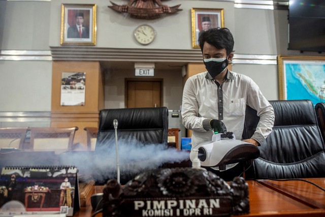 Pegawai melakukan disinfeksi di ruang rapat Komisi I DPR, Kompleks Parlemen, Senayan, Jakarta, Rabu (2/2/2022). Foto: Muhammad Adimaja/ANTARA FOTO