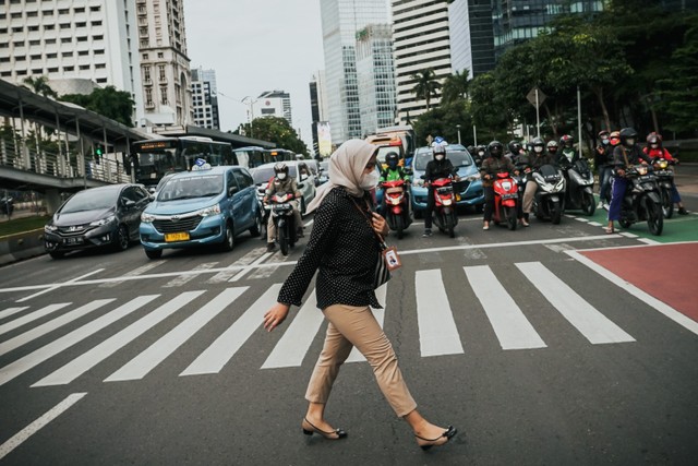 Pekerja berjalan sepulang kerja di kawasan Jalan Jenderal Sudirman, Jakarta, Rabu (2/2/2022).  Foto: Jamal Ramadhan/kumparan