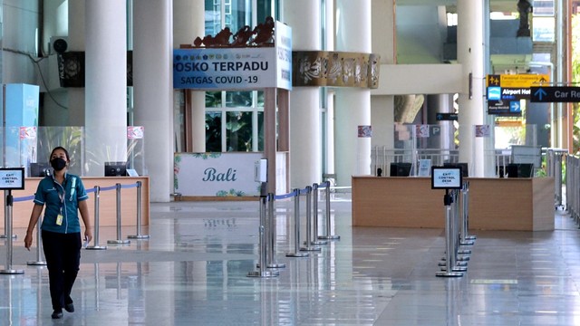 Pekerja melintas di area Terminal Internasional yang lengang di Bandara Internasional I Gusti Ngurah Rai, Badung, Bali, Rabu (2/2/2022). Foto: Fikri Yusuf/Antara Foto
