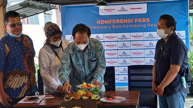 Pengelola Pasar Ikan dan Restoran Balekambang, Solo memotong tumpeng dalam perayaan ulang tahun pertama pasar tersebut, Kamis (03/02/2022). FOTO: Agung Santoso