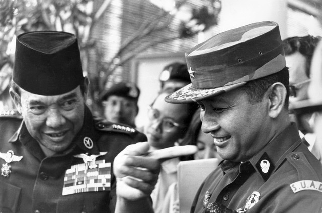 Presiden Indonesia Sukarno (kiri) sedang berbicara dengan Jenderal Suharto setelah sesi pembubaran komando Malaysia, 24 Agustus 1966, di Jakarta. Foto: PANASIA-FILES / AFP