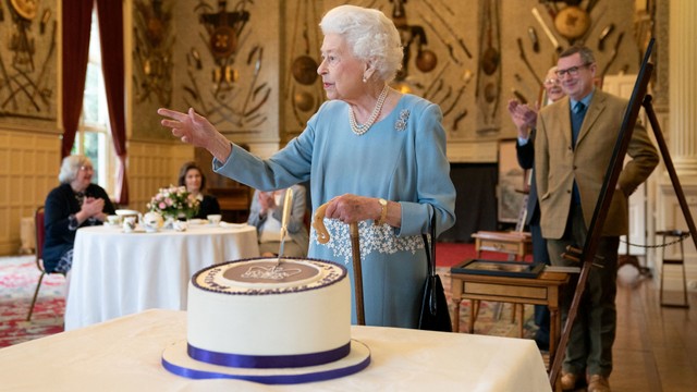 Ratu Elizabeth II Inggris memotong kue untuk merayakan Platinum Jubilee di Ballroom Sandringham House, Inggris, Sabtu (5/2/2022). Foto: Joe Giddens/Reuters