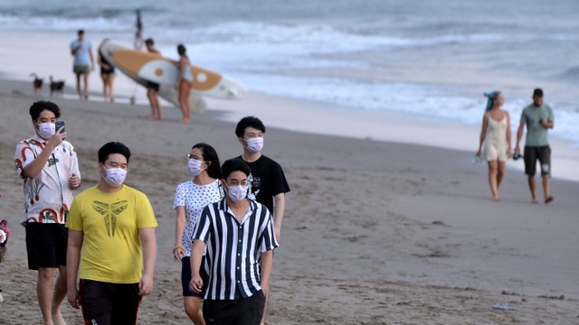 Warga membersihkan papan selancar untuk disewakan kepada wisatawan di kawasan wisata Pantai Batu Bolong, Canggu, Badung, Bali, Senin (7/2/2022). Foto: Fikri Yusuf/Antara Foto