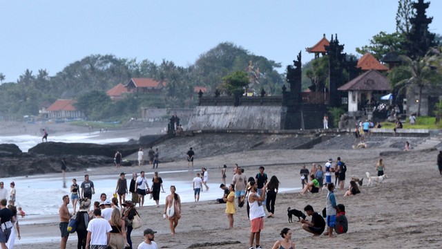 Warga membersihkan papan selancar untuk disewakan kepada wisatawan di kawasan wisata Pantai Batu Bolong, Canggu, Badung, Bali, Senin (7/2/2022). Foto: Fikri Yusuf/Antara Foto
