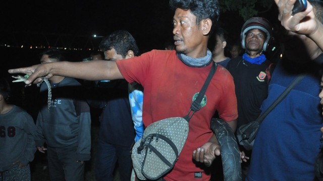 Tili, Penakluk Buaya Berkalung Ban di Palu saat menunjuk buaya yang ditangkapnya di Sungai Palu, Senin malam (7/2). Foto: PaluPoso