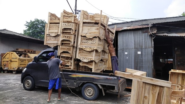 Pedagang Pasar Mebel, Solo menaikkan furnitur ke atas pick up di pasar tersebut, Rabu (09/02/2022). FOTO: Tara Wahyu