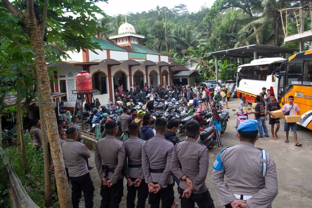 Anggota Polisi berjaga saat warga yang sempat ditahan tiba di halaman masjid Desa Wadas, Bener, Purworejo, Jawa Tengah, Rabu (9/2/2022). Foto: Hendra Nurdiyansyah/ANTARA FOTO