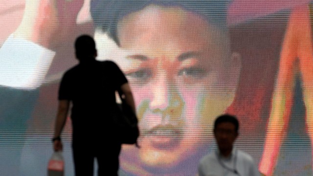 Pria berjalan melewati monitor yang menunjukkan berita Pemimpin Korea Utara Kim Jong Un uji coba rudal balistik antarbenua Korea Utara di Tokyo, Jepang, 4 Juli 2017. Foto: REUTERS/Toru Hanai