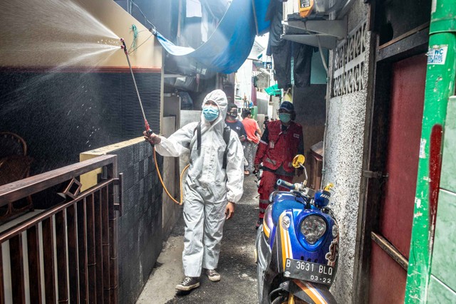 Petugas PMI menyemprotkan cairan disinfektan di area permukiman warga di kawasan Kelurahan Maphar, Jakarta, Kamis (10/2/2022).  Foto: Muhammad Adimaja/ANTARA FOTO