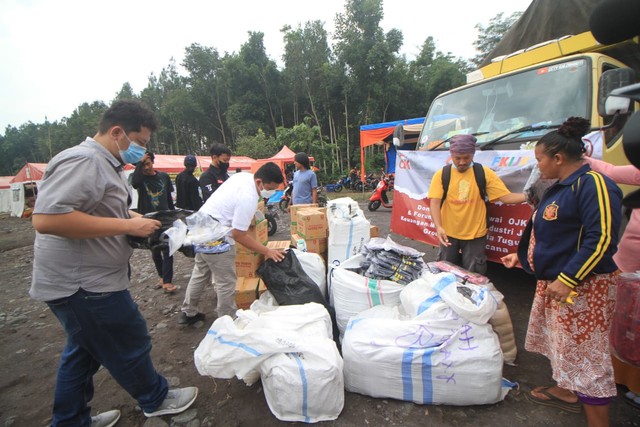 Rombongan OJK Malang dan Tugu Media Group saat membagikan bantuan ke tenda pengungsian lapangan Desa Penanggal. Foto: Loah Mahfud
