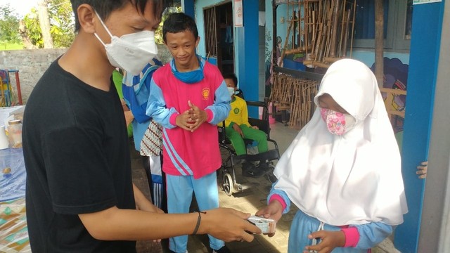 Kegiatan pembagian susu kepada murid SLB Muhammadiyah Gamping. Kredit foto : Hesty Feliyantisha/Mahasiswi KKn 257 UMY.