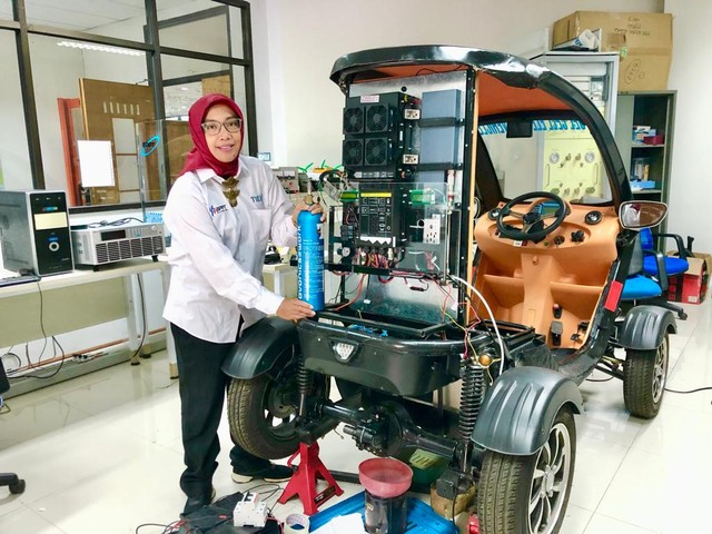 Eniya Listiani Dewi, peneliti BRIN saat menunjukkan mobil berbahan bakar hidrogen hasil litbang BRIN di Laboratorium Fuel Cell dan Hidrogen, Puspiptek, Serpong (sumber foto: BRIN)